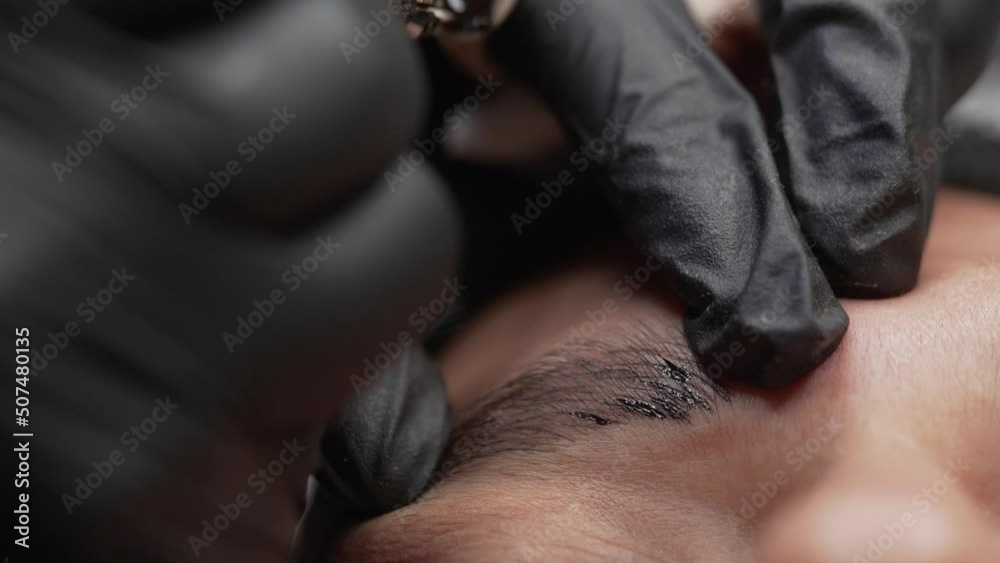 Extreme close-up of micro blading procedure on a man's eyebrow