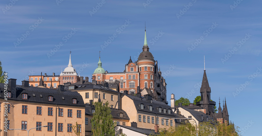 Old houses on a hill in the district Södermalm with tin roofs and dorms a sunny summer day in Stockholm