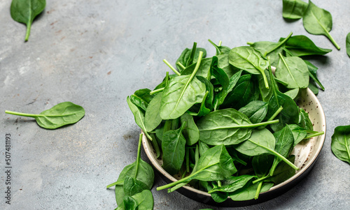 Close up Spinach. Raw organic fresh baby spinach leaves in a metal bowl on dark background. Food recipe background., top view