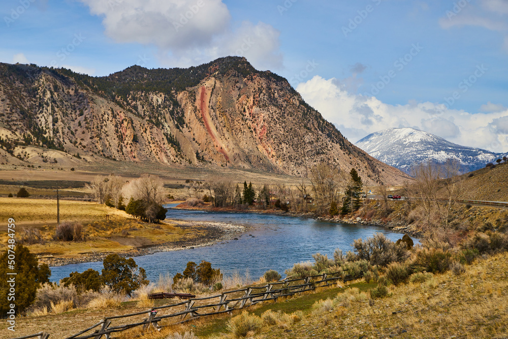 Beautiful landscape of dry and snowy mountains with wide river in foreground