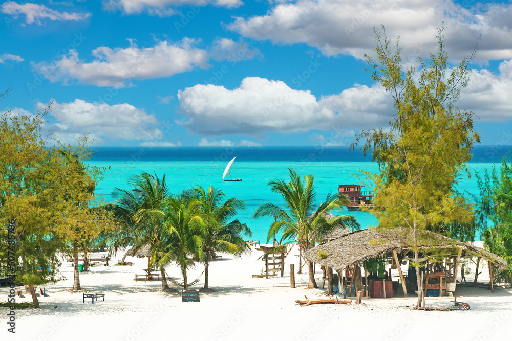 Beautiful tranquil empty bright white paradise sand beach, sun beds, palm trees, bamboo hut bar, turquoise water - Paje, Zanzibar - obrazy, fototapety, plakaty 