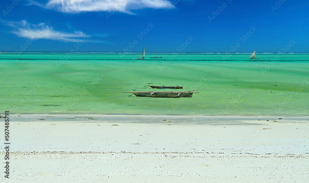 Beautiful empty deserted bright white sand beach, turquoise green shallow calm sea, traditional wooden dau boat, clear blue sky horizon - Zanzibar, indian Ocean Beautiful empty deserted bright white sand beach, turquoise green shallow calm sea, traditional wooden dau boat, clear blue sky horizon - Zanzibar, indian Ocean