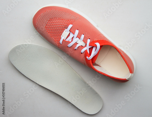 Orange sport shoes with orthopedic insoles on neutral background.. Top view. photo