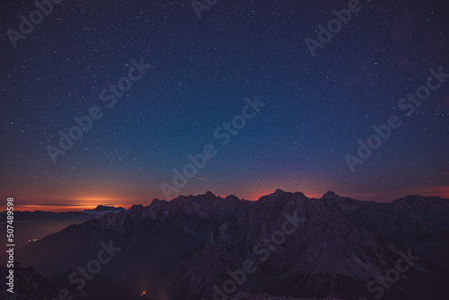 Sunset and stars at dusk in Julian alps mountain range. Serenity and friendship in the mountains.