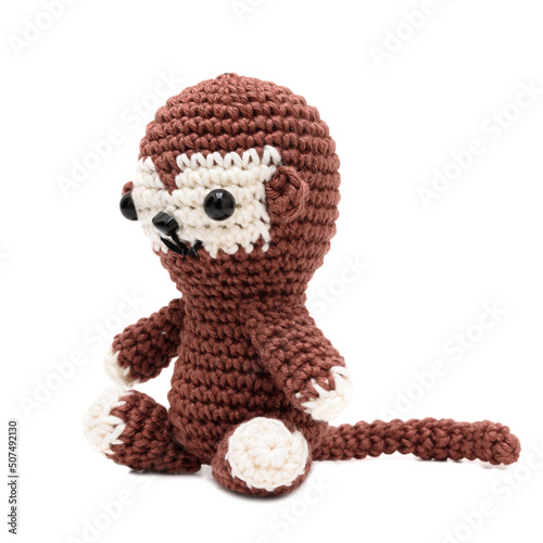 Foto Mini macaco de pelúcia de perfil feito na técnica de crochê amigurumi sobre fundo branco