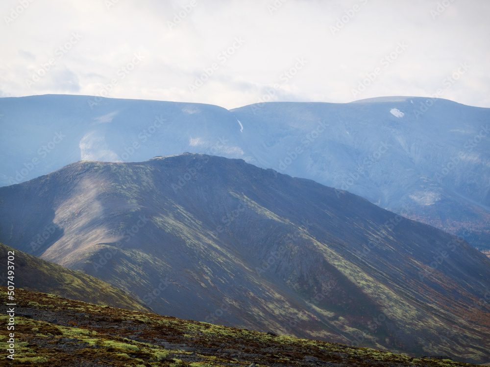 Autumn colorful tundra on the background mountain peaks. Mountain landscape in Kola Peninsula, Arctic, Khibiny Mountains.