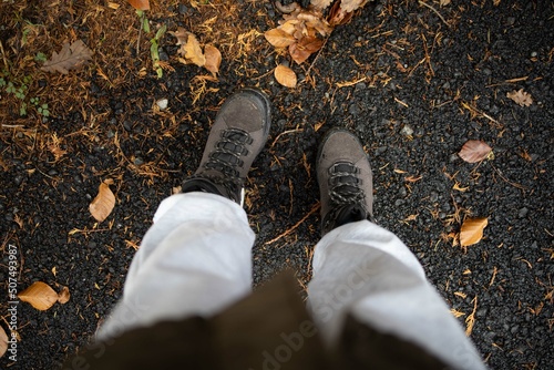 Person on hiking boots walking rainy.Close up of hiker walking down the wet.
