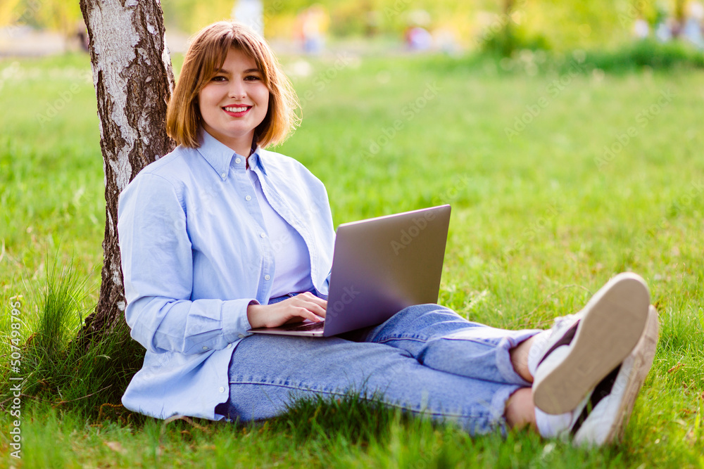 Photo portrait of pretty young woman smiling teeth sitting in green park working on laptop smiling Photo portrait of pretty young woman smiling teeth sitting in green park working on laptop smiling