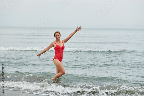 girl in a red swimsuit walking on the beach
