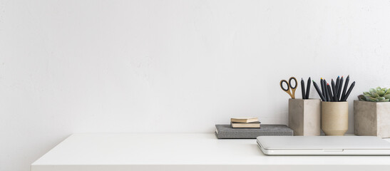 Home office, creative desk with office supplies and wall space.