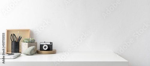 Home office table with office supplies  vintage camera and white table space. Banner.