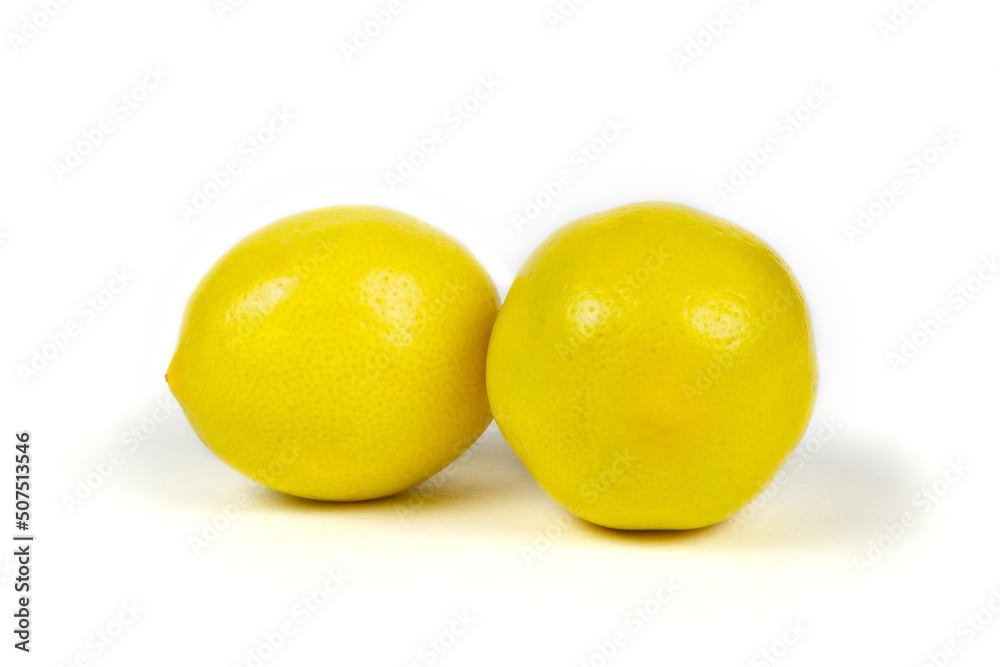 Two fresh beautiful yellow lemons on a white isolated background close-up. Two fresh beautiful yellow lemons on a white isolated background close-up.