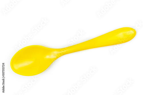Bright yellow plastic spoon for feeding the baby on a white isolated background.