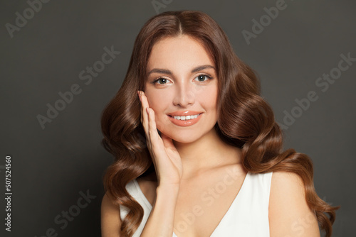 Glamorous lady with long wavy brown coloring hair and healthy skin. Perfect woman, studio portrait