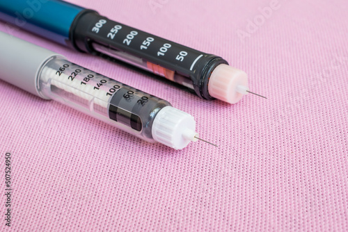 Insulin pen injector. Insulin pen fill with needle on pink background. Diabetes Day. photo