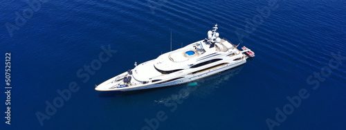 Aerial drone ultra wide panoramic photo of beautiful modern super yacht with wooden deck anchored in deep blue open ocean sea © aerial-drone