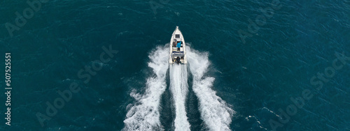 Aerial drone ultra wide photo of luxury rigid inflatable speed boat cruising in high speed in Aegean deep blue sea, Greece © aerial-drone