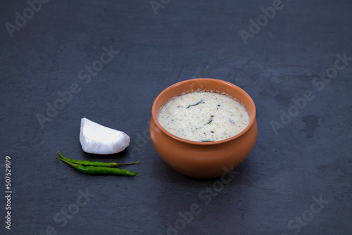 Fresh made Indian food, chutney, Coconut chutney in a bowl with raw coconut. Served with dosa, idli, vadai, Pongal. Selective focused home made coconut chutney in isolated white background. photo