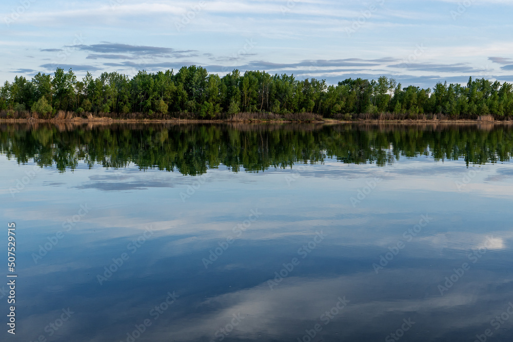 Obraz premium reflection of trees and sunset sky in river water