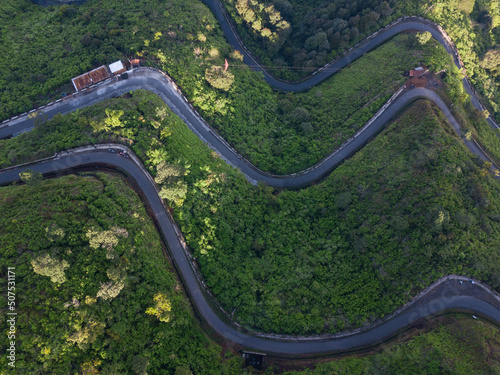 Overhead Drone photo of the road on the slopes of a mountain and surrounded by dense forest. It located in Mount Telomoyo in clear weather