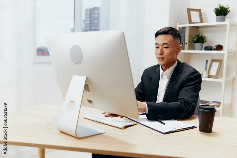 manager in a suit glass of coffee sits at a tablein front of a computer Lifestyle manager in a suit glass of coffee sits at a tablein front of a computer Lifestyle