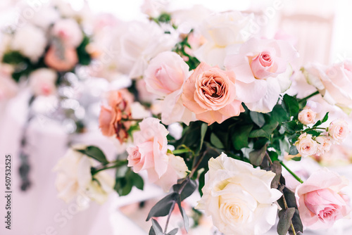 Wedding decoration table in the hall, floral arrangement. In the style vintage. Decorated dining table with flowers for guests and newlyweds, in peach-pink, pastel color. © Ivan