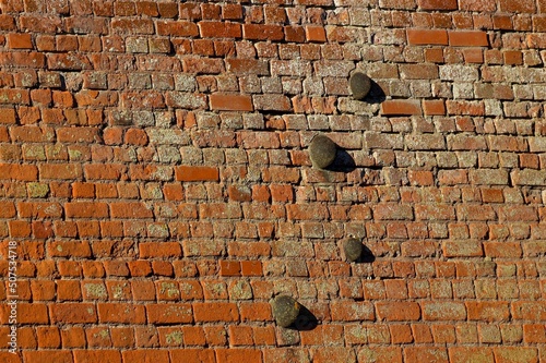 old brick wall with cracks and canon balls