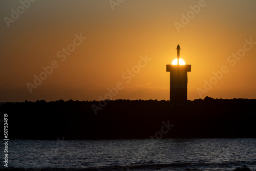 sunset in the galapagos islands with a lighthouse sea lions and pelicans over the pacific ocean