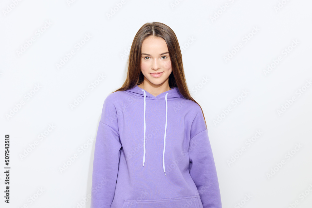 a calm woman stands on a white background in a purple tracksuit relaxing her body and smiling a little a calm woman stands on a white background in a purple tracksuit relaxing her body and smiling a little