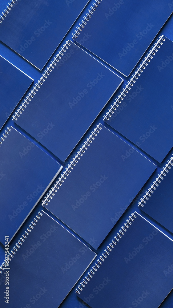 Minimal workspace with blue notebooks on a blue background. Office concept. Mockup. Top view.