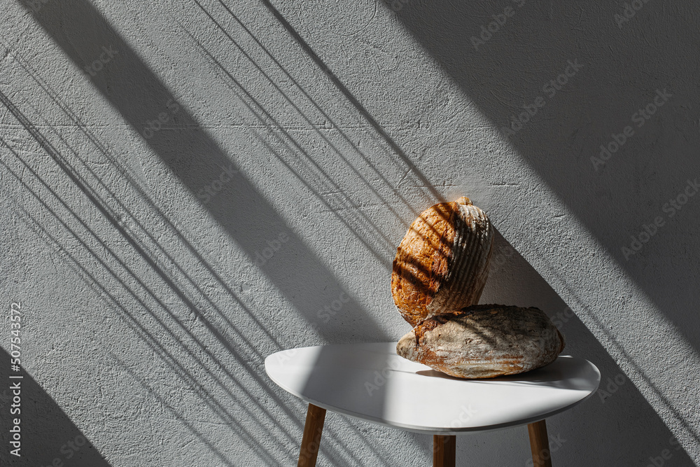 Delicious freshly baked bread in the sun on a white table. Delicious freshly baked bread in the sun on a white table.