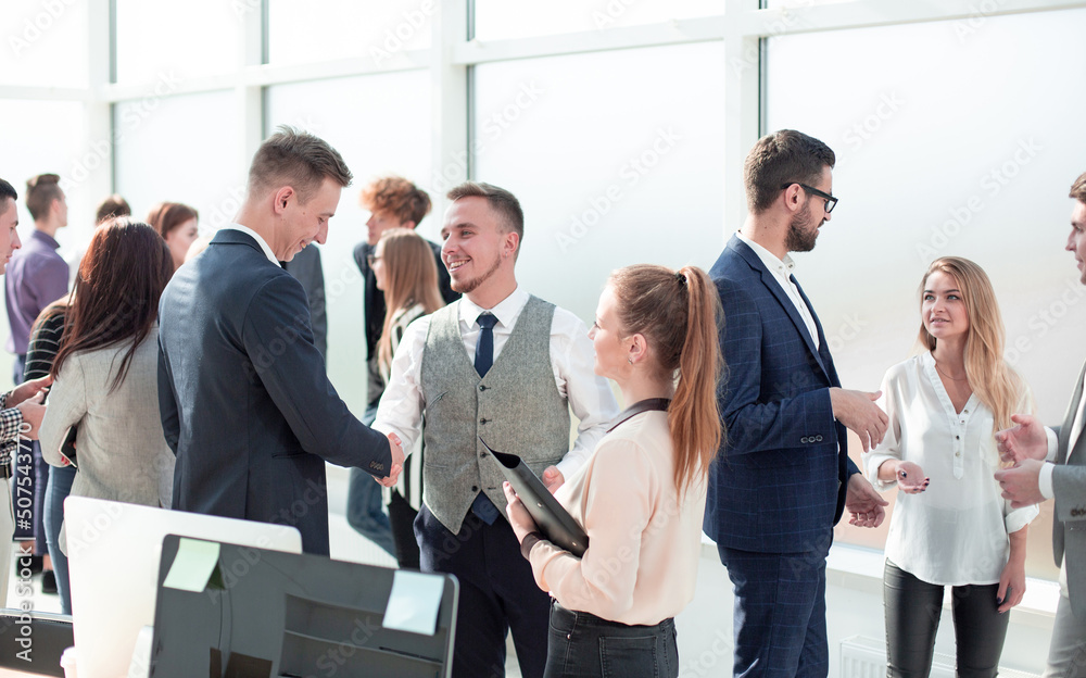 group of diverse employees discussing standing in the office group of diverse employees discussing standing in the office