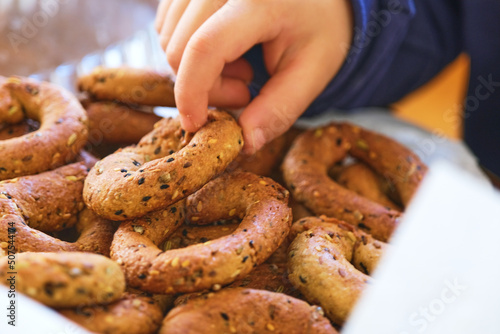 Child hand holding special Gaziantep Köy Kahkesi Known As "Rustic Cookie". Turkish Sesame and Black Cumin Cookie. Selective Focus