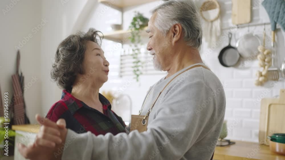 Asian mature senior couple is dancing and smiling in kitchen at home. Asian mature senior couple is dancing and smiling in kitchen at home.