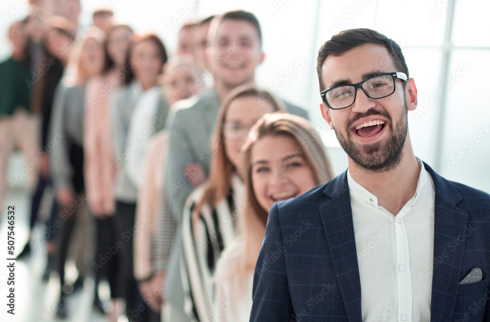 smiling business man standing in front of a group of diverse young people smiling business man standing in front of a group of diverse young people