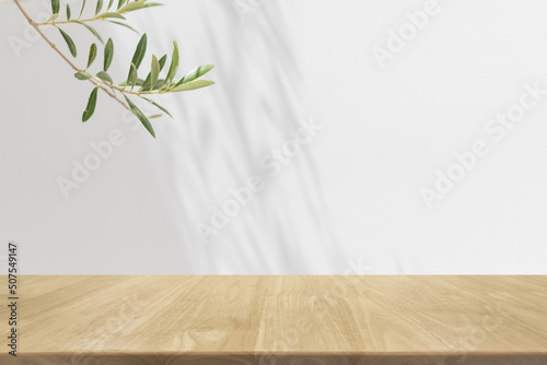 Empty wood table top and blurred white wall in garden background with Green leaves - can used for display or montage your products.