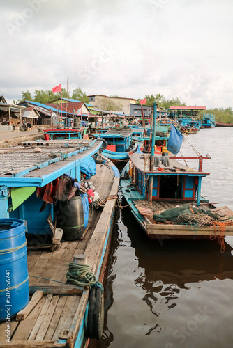 Fishing village. Fiherman village. Fishing boats lean on the riverbank. Boats on the river. photo