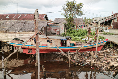 Fishing village. Fiherman village. Fishing boats lean on the riverbank. Boats on the river. photo