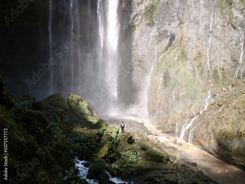 man standing in front of the waterfall
