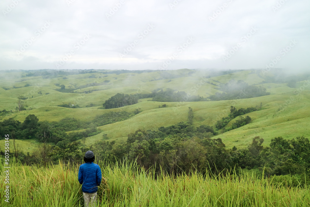 Man standing in middle of green hills. West Kalimantan. Man standing in middle of green hills. West Kalimantan.