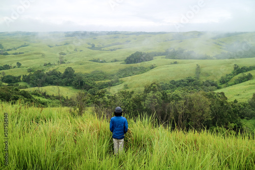Man standing in middle of green hills. West Kalimantan. © Fani