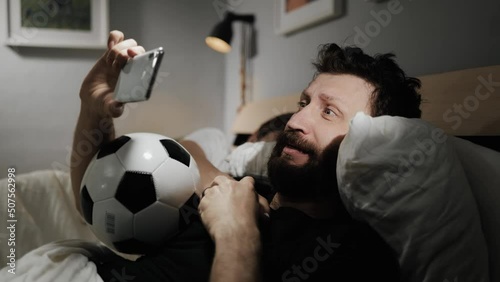 Soccer fan. Bearded male fan is watching online broadcast of football match. Emotional man joyfully screaming, victory, goal
