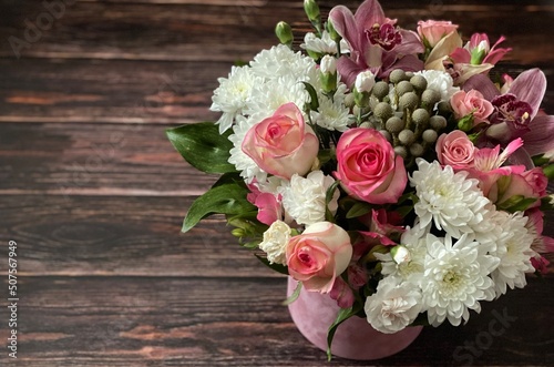 Vintage wooden surface  A beautiful bouquet with different flowers in a round box on a wooden brown textured background. Concept of greeting or invitation card. Thank you card  copy space