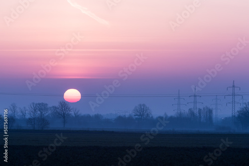 Quadro su tela Wschód Słońca, słupy energetyczne