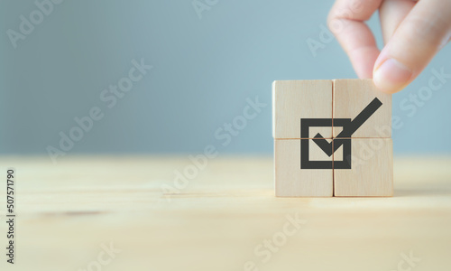 Corporate regulatory and compliance. Goals achievement and business success. Task completion. Ethical corporate. Do the right thing. Quality and ISO symbol. Placing wooden cube with checkmark icon.
