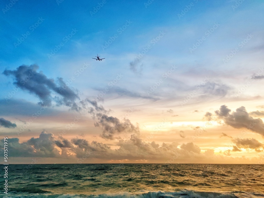A photograph of an airplane with a seascape on the background