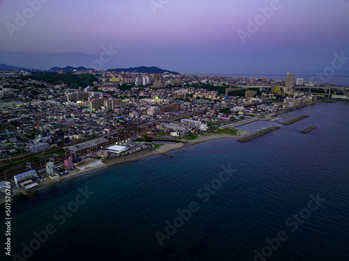 Aerial view of post-sunset glow over coastal town on point © Osaze
