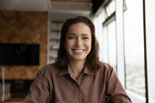 Head shot portrait of happy confident business woman looking at camera, smiling during video call talk. Female blogger, coach, teacher speaking to audience from screen, giving online virtual training