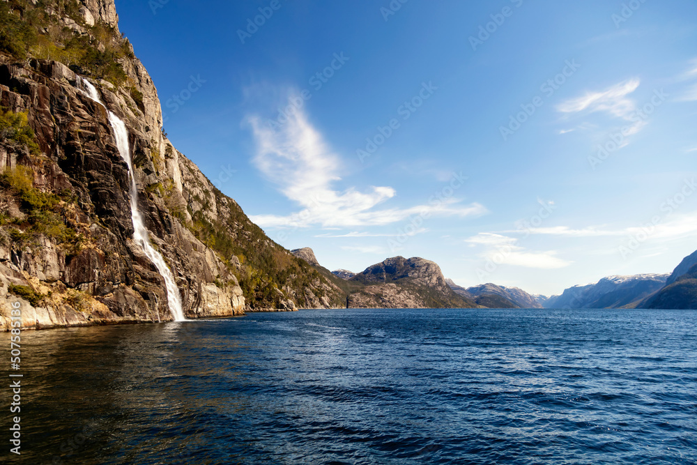 View of Norwegian waterfall cascading into Lysefjorden fjord