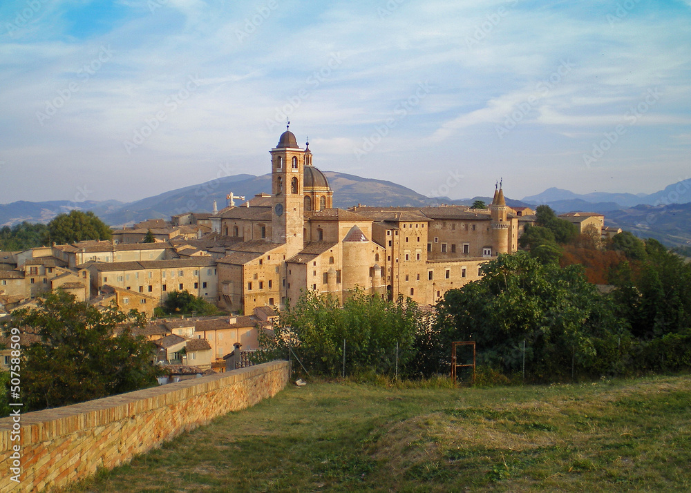 A beautiful panoramic view of the renaissance town of Urbino in the Le Marche region of Italy showing the historical Ducal Palace and the wonderful hilly and mountainous landscape beyond